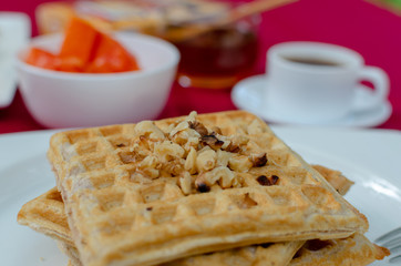 Desayuno saludable - waffles de harina del negrito, servidos con nueces, papaya, miel y café