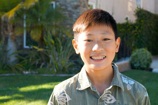 Portrait of young Asian boy with tooth braces. Young teen boy smiling and showing his orthodontic braces on his teeth.