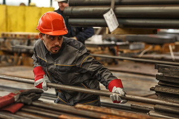 Horizontal shot of a handsome young warehouse manager organizing steel supplies wearing protective...