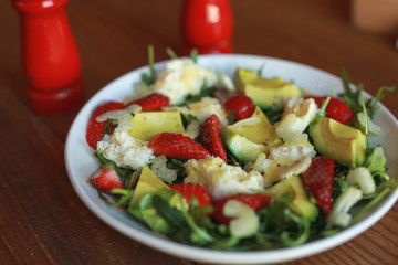 Fresh salad with strawberry and avocado in a plate