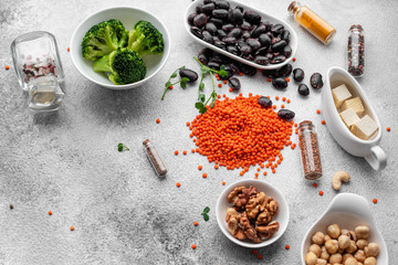 Superfoods on a gray background with copy space. Nuts, beans, greens and seeds. Healthy vegan food