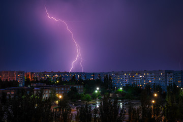 Naklejka na ściany i meble Lightning strikes down over the city at night. Beautiful shot. Long Exposure Photography