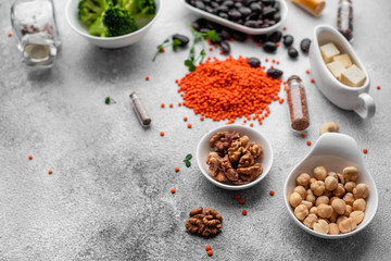 Superfoods on a gray background with copy space. Nuts, beans, greens and seeds. Healthy vegan food