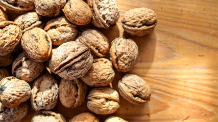 Orzechy włoskie leżące na drewnianej desce w słoneczny dzień