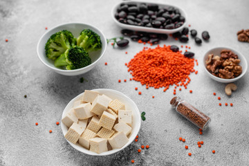 Superfoods on a gray background with copy space. Nuts, beans, greens and seeds. Healthy vegan food