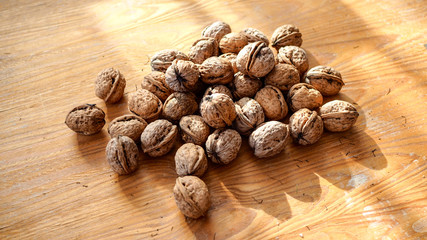 Orzechy włoskie leżące na drewnianej desce w słoneczny dzień