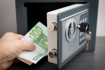 Man puts euro banknotes in the safe