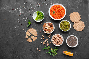 Superfoods on a gray background with copy space. Nuts, beans, greens and seeds. Healthy vegan food