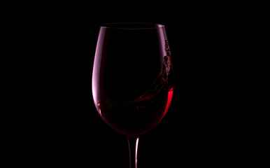 Silhouette of glass of red wine on black background