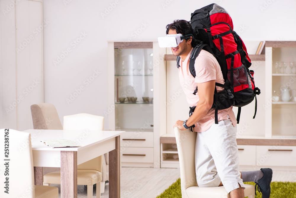 Wall mural young male tourist with virtual glasses preparing for trip