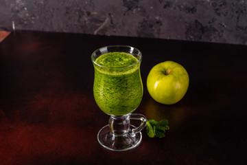 Ginger green apple smoothie on concrete background. It can be used as a background