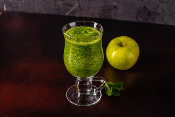 Ginger green apple smoothie on concrete background. It can be used as a background