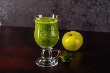 Ginger green apple smoothie on concrete background. It can be used as a background