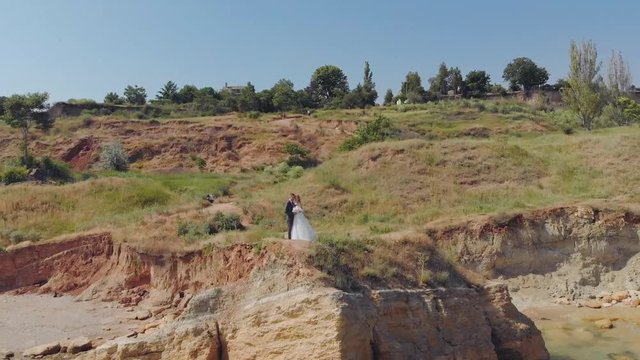 Loving bridal couple, wedding sea horizon, cliffs background, aerial view