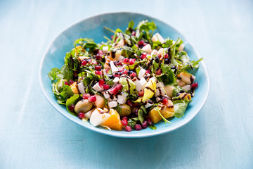 Arugula, apple, orange, pomegranate, goat cheese. Salad of ruccola, goat cheese, fruit with olive oil. Light breakfast 