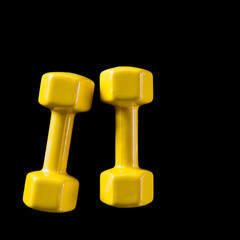 Two yellow dumbbells on a black background