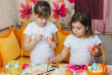 Two cute pretty preschool girl prepare easter eggs, drawing eggs together. Friendship, childhood, easter concept