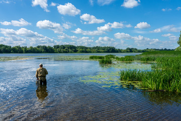 Fisherman with a fishing rod on the background of nature