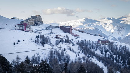 View of La Plagne Aime 2000 ski resort in French Savoy Alps. Snow covered mountains and buildings...