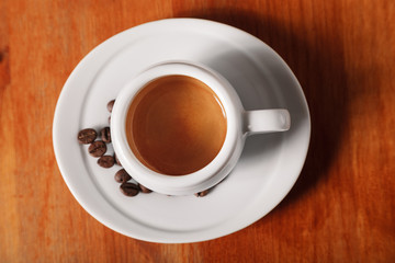 White coffee Cup with delicious foam, close-up top view on wooden background. Concept of coffee break and serving coffee