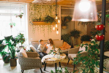 Mom and son with flowers in caffe. Son give flowers to mother. cute family. International women`s day, 8 march celebrating