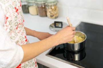 Supermom preparing dinner for a baby in a white modern kitchen