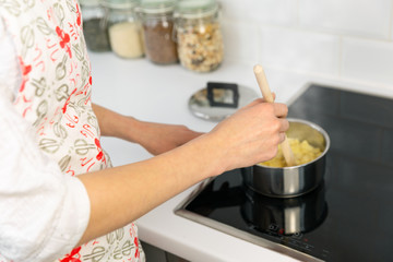 Fototapeta na wymiar Supermom preparing dinner for a baby in a white modern kitchen