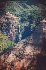 Contrasty image where a natural cascade falls over brown dry ground
