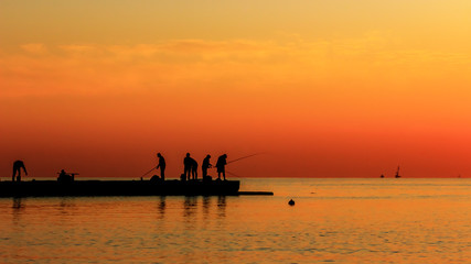 Naklejka na ściany i meble Fishermen catch fish at sunrise