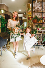 Mom and son with flowers in caffe. Son give flowers to mother. cute family. International women`s day, 8 march celebrating