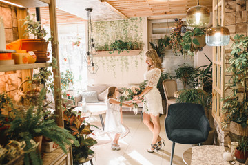 Mom and son with flowers in caffe. Son give flowers to mother. cute family. International women`s day, 8 march celebrating