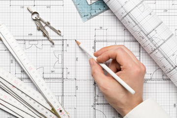 Architect pointing on architectural blueprint house building plan with pencil, ruler, compasses and...