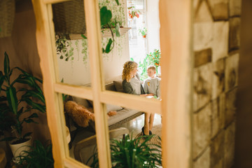 Mom and son with flowers in caffe. Son give flowers to mother. cute family. International women`s day, 8 march celebrating