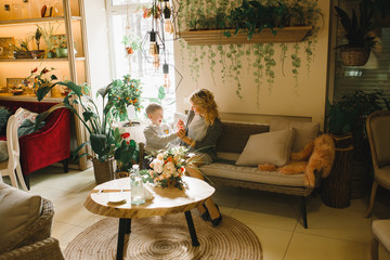 Mom and son with flowers in caffe. Son give flowers to mother. cute family. International women`s day, 8 march celebrating