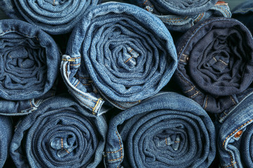 Fototapeta na wymiar Background of a stack rolled jeans, space for text