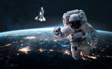 Astronaut in outer space near Earth planet. Space shuttle and stars on background. Elements of this...