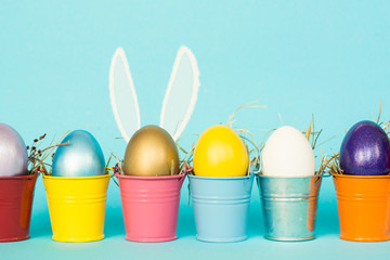 Easter eggs with Rabbit ears in colored buckets, selective focus image, Card Happy Easter 