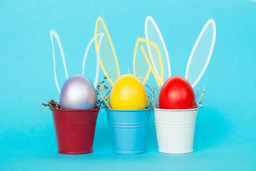 Fototapeta na wymiar Easter eggs with Rabbit ears in colored buckets, selective focus image, Card Happy Easter 