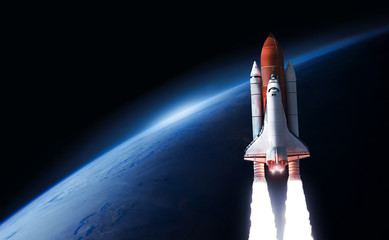 Space shuttle in the space near Earth planet. Black background. Atmosphere. Elements of this image furnished by NASA