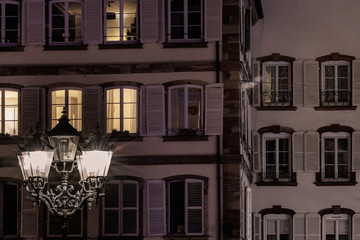 Obraz premium Street lamp and buildings with highlighted windows, night view of Strasbourg