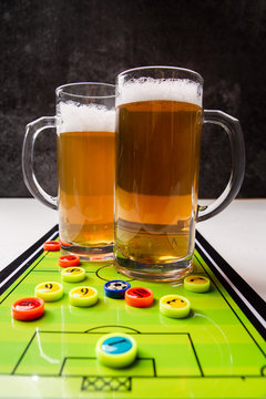 Image of two mugs of beer, table football