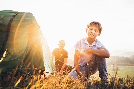 Father and son prepare for mountaing camping, set up the tent. Trekking with kids concept image