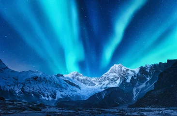 Fotobehang Aurora borealis boven de besneeuwde bergketen in Europa. Noorderlicht in de winter. Nachtlandschap met groene poollichten en besneeuwde bergen. Sterrenhemel met aurora over de rotsen. Ruimte © den-belitsky