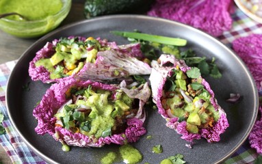taco keto diet food is wrapped instead of cakes in cabbage leaf of Peking cabbage with avocado mayo, diced avocado, ground beef, onions, corn and cilantro, healthy fats without carbohydrates.