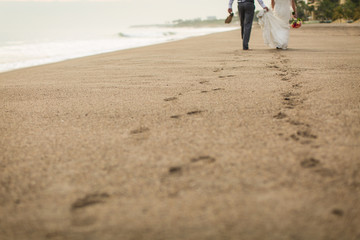 Bride and Groom Walking Barefoot on Beach