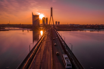 Stunning aerial view of Riga, Latvia during purple orange sunset. View of the old town, suspension...