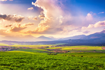 Picturesque green fields and meadow landscape. Panorama of Slovakia Tatras mountains in spring.