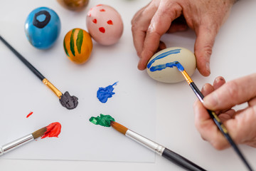 Male hands painting easter eggs.