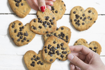 Couple in love holding heart shaped cookies 