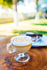 Latte coffee and cake on wooden table at outdoor